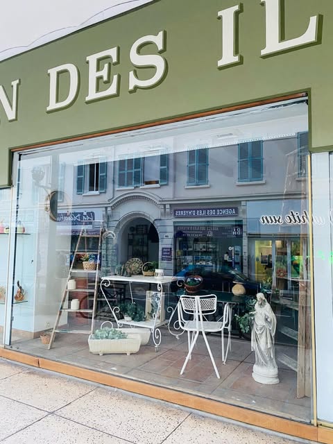 La vitrine avec du mobilier de jardin en métal blanc et une statue